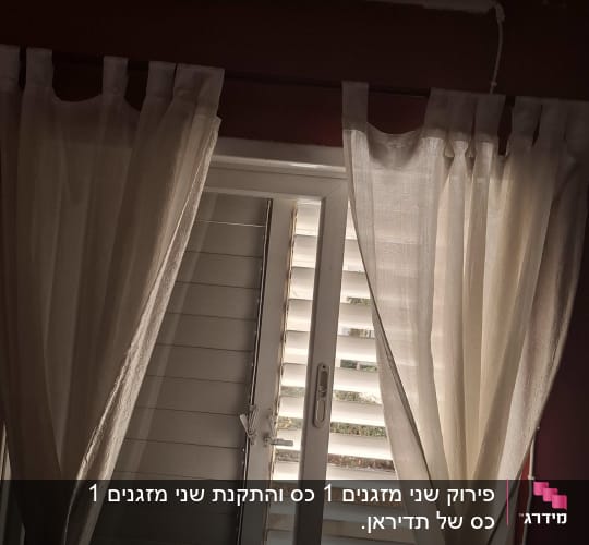 מזגן מותקן מעל חלון עם וילונות לבנים